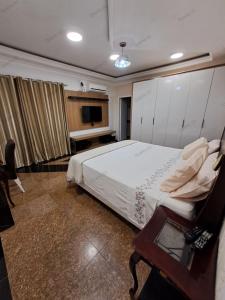 a bedroom with a bed and a table and a television at Pandolfo Locações - Casa Foz Oficial in Foz do Iguaçu