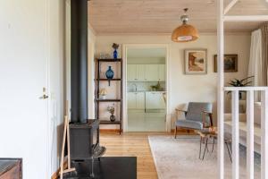 uma sala de estar com um fogão a lenha e um quarto em A countryside villa close to Uppsala! em Uppsala