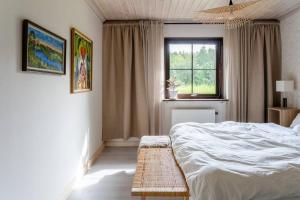 1 dormitorio con cama blanca y ventana en A countryside villa close to Uppsala!, en Uppsala