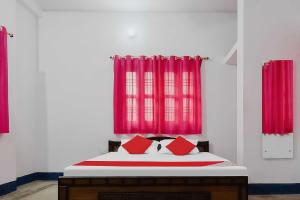 a bedroom with a bed with red curtains at OYO Flagship Aashirvaad Green's Guest House in Patna
