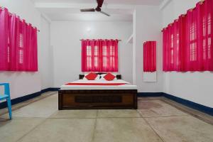 a bedroom with red curtains and a bed in a room at OYO Flagship Aashirvaad Green's Guest House in Patna