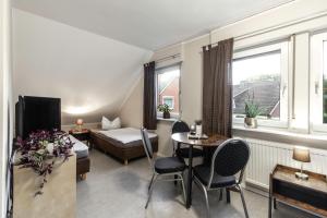 a hotel room with a bed and a table and chairs at Pension Haus am Kohfurth in Norderstedt