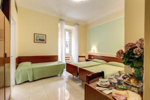 una camera d'albergo con due letti e un tavolo con piatti di Hotel Igea a Roma Altre 28 foto