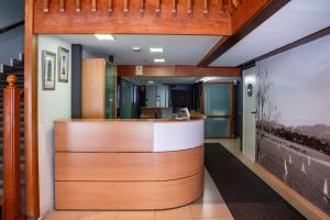 an office lobby with a reception counter with wood at Hotel San Glorio in Santander