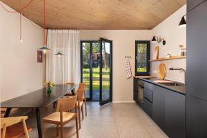 cocina y comedor con mesa y sillas en Elf am See - Haus 10, en Templin