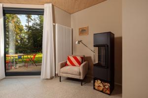 a living room with a chair and a television at Elf am See - Haus 10 in Templin