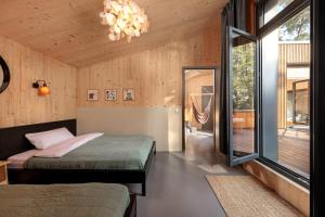 1 dormitorio con cama y lámpara de araña en Elf am See - Haus 10, en Templin