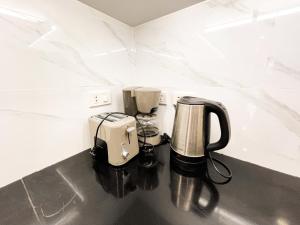eine Kaffeemaschine und eine Kaffeemaschine auf der Theke in der Unterkunft Kandi Palace Hotel D20 in Angeles