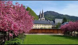 un gran edificio con un gran patio con flores rosas en FeApp Jennerblick Maria Gern, en Hintergern
