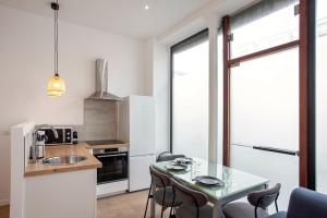 Una cocina con una mesa y sillas y un fregadero. en Luxury apartment Alfortville, en Alfortville 9 fotos más