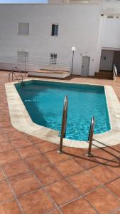 a large swimming pool with blue water in a building at Bonito Apartamento Costa Tropical in Polopos