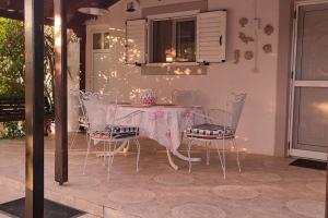 uma mesa de jantar com cadeiras e uma toalha de mesa rosa em garden house nafplio em Nafplio