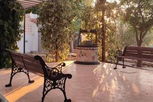 two benches sitting on a patio with a fountain at garden house nafplio in Nafplio