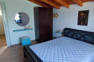 um quarto com uma cama com uma cómoda e um espelho em garden house nafplio em Nafplio