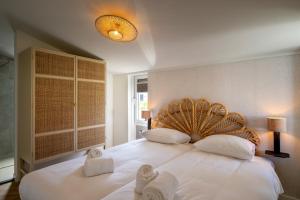 a bedroom with a large white bed with towels on it at Slapen aan zee by Droomvilla in Sint Maarten +21 photos