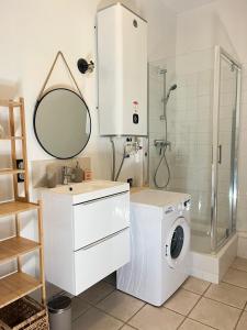 a white bathroom with a washing machine and a mirror at Alaimo et Les2Roses in Paray-le-Monial