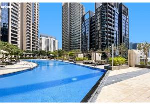 een groot zwembad in een stad met hoge gebouwen bij bnbmehomes - Breathtaking Downtown Views at BLVD - 3801 in Dubai