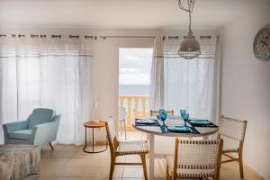 een eetkamer met een tafel en stoelen en een raam bij Casa Laguna in Costa Calma