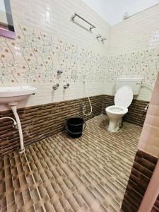 uma casa de banho com um WC e um lavatório em Mangalam guest house em Puri