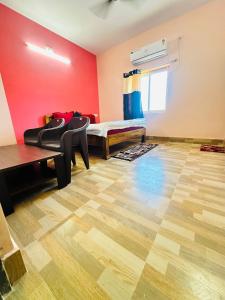 um quarto com uma cama e piso em madeira em Mangalam guest house em Puri
