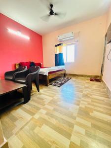 um quarto com uma cama, um sofá e uma mesa em Mangalam guest house em Puri