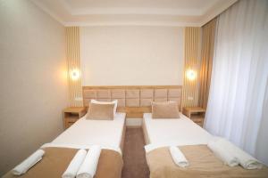 烏爾根奇的住宿－Hotel Tinchlik Plaza，酒店客房设有两张床和两盏灯。