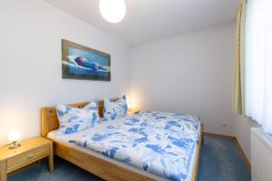 una camera da letto con letto con lenzuola e cuscini blu di Pension Klug Adults only - DorfResort Mitterbach a Mitterbach