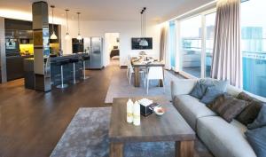 a living room and kitchen with a couch and a table at BoardingHouse Mannheim in Mannheim