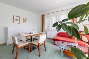米特爾巴赫的住宿－Pension Klug Adults only - DorfResort Mitterbach，客厅配有桌子和红色沙发