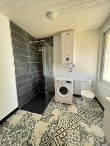 a bathroom with a washing machine and a toilet at Alaimo et Les2Roses in Paray-le-Monial