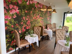 a floral wall in a restaurant with tables and chairs at Basel Airport Stay in Blotzheim