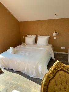 a bedroom with a large bed with white sheets at Basel Airport Stay in Blotzheim