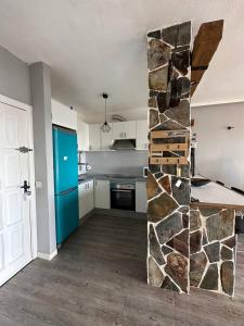a kitchen with a stone wall in the middle of a room at Apto increíble, acogedor, luminoso de ambiente muy relajante con excelentes vistas y servicios/ Amazing apt with sunset lovely views in Adeje