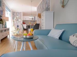 a blue couch in a living room with a bowl of fruit on a table at Florida Haus am Strand in Boltenhagen