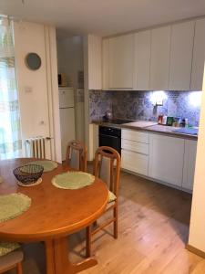 a kitchen with a wooden table and a table and chairs at Apartman Luka in Slavonski Brod