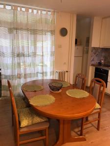a dining room table with chairs and a wooden table at Apartman Luka in Slavonski Brod