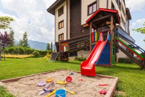 a playground with a slide in the yard of a house at Pirin Bliss Apartment Ski, Spa and Relax at Terra Complex in Razlog