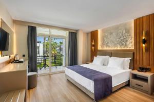 una camera con letto e balcone di Simena Comfort Hotel a Kemer