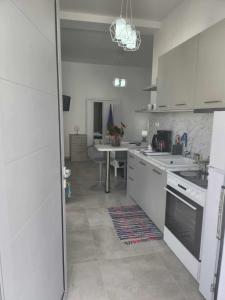 a kitchen with white appliances and a table in it at ANDRIANOS DELUXE STUDIO in Matala