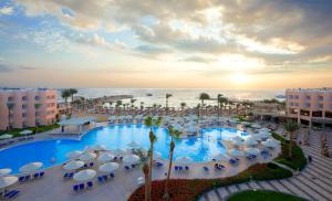 an aerial view of a resort pool with umbrellas and the ocean at Beach Albatros The Club - Aqua Park in Hurghada +195 photos