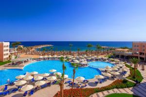 Beach Albatros Aqua Park - Hurghada في الغردقة: إطلالة علوية على مسبح مع مظلات والمحيط