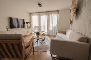 a living room with a couch and a tv at Slapen aan zee by Droomvilla in Sint Maarten