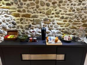 uma mesa com comida em frente a uma parede de pedra em Les Remparts em Mirepoix