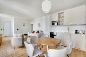 eine Küche und ein Esszimmer mit einem Tisch und Stühlen in der Unterkunft Pick A Flat's Apartments in Opéra - Rue d'Hauteville in Paris