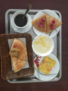 a tray with three plates of food and a cup of coffee at Hotel Marvarid in Samarkand