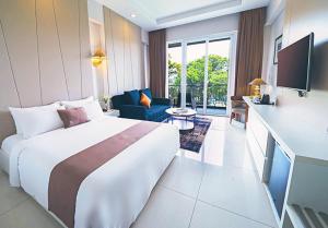 a hotel room with a large bed and a living room at R Hotel Rancamaya in Bogor