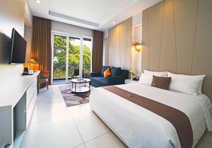 a hotel room with a large bed and a living room at R Hotel Rancamaya in Bogor
