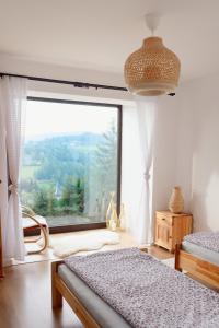 a bedroom with two beds and a large window at Domek u Jędrusia in Nowy Targ