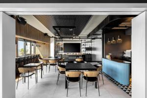 a dining room with tables and chairs and a tv at Prima Tel Aviv Hotel in Tel Aviv