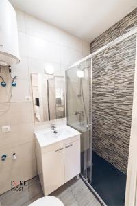 La salle de bains est pourvue d'un lavabo blanc et d'une douche. dans l'établissement Aluche Apartments, à Madrid